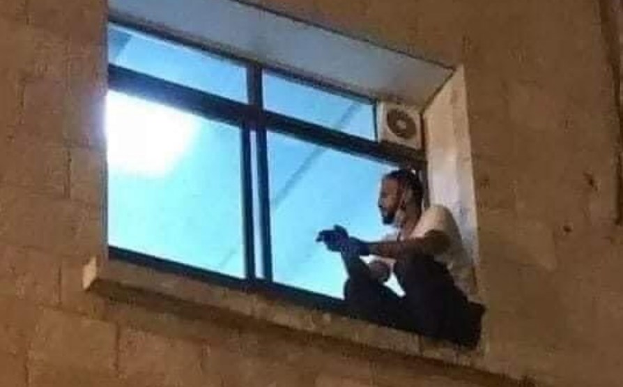 Foto de Jihad Al-Suwaiti trepado en la ventana de un hospital
